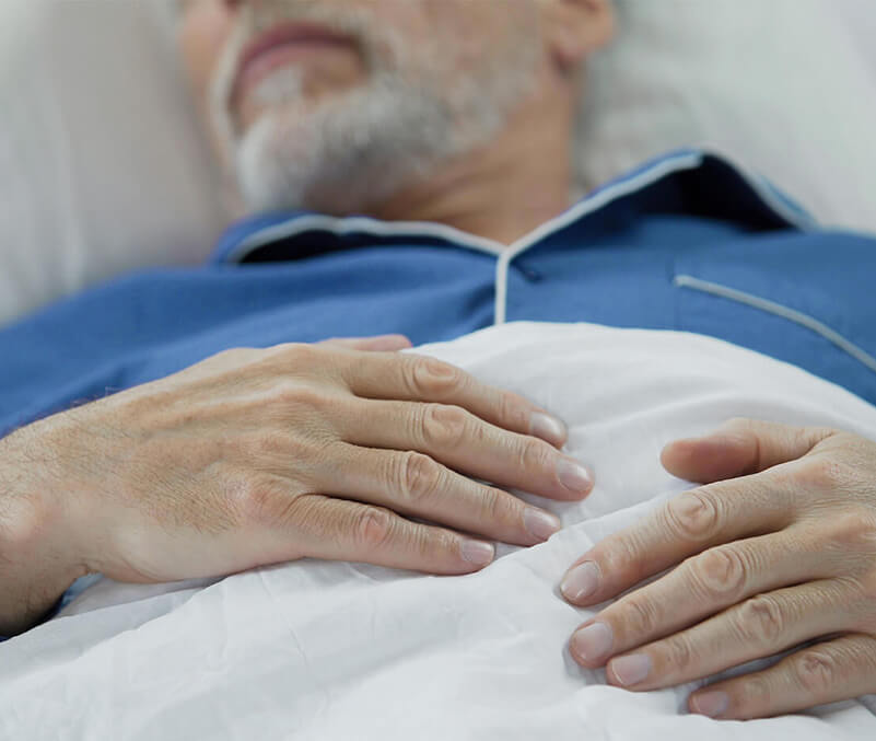 Older man laying in bed