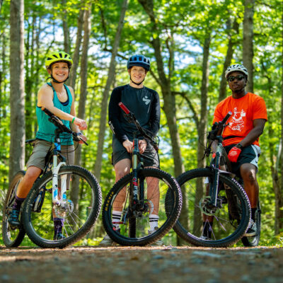 Mountain bike enthusiasts and UMaine outdoor leadership community members, left to right, Lauren Jacobs, Patrick Downing and Trevor England. The KPE Outdoor and Adventure Activities class includes winter shelter construction.