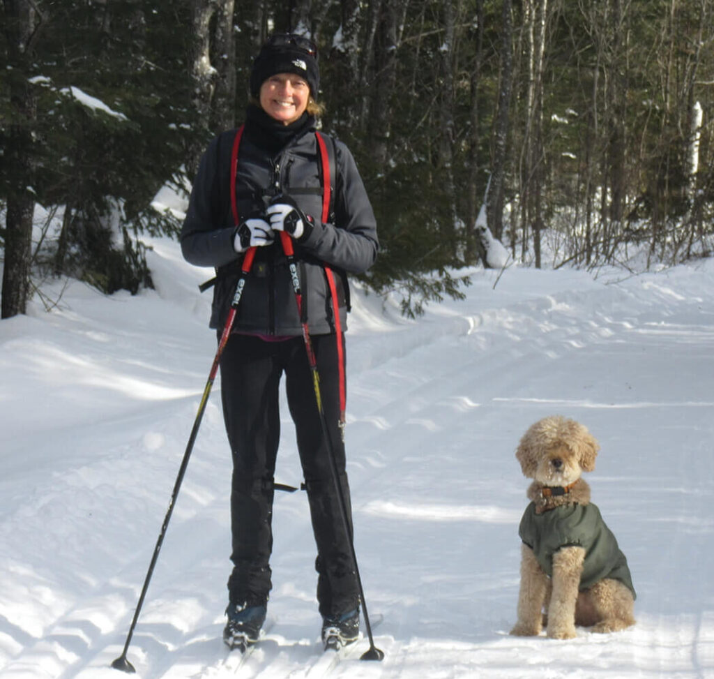 Woman cross country skiing with dog