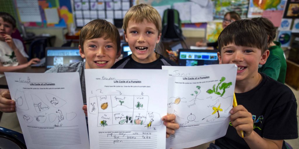 Group of boys showing off a worksheet